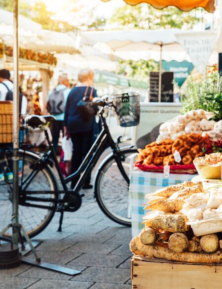 Viktualienmarkt oder großer Bauernmarkt in München, bei Sonnenschein mit vielen Menschen  | © Gettyimages.com/Nikada